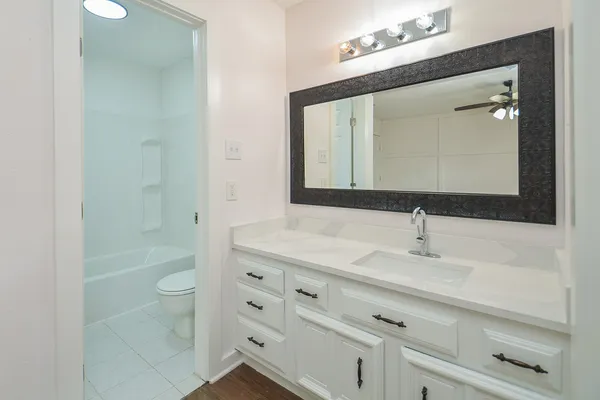a bathroom with a double vanity sink mirror and shower