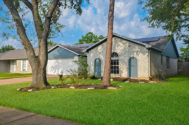 a front view of a house with a garden and plants