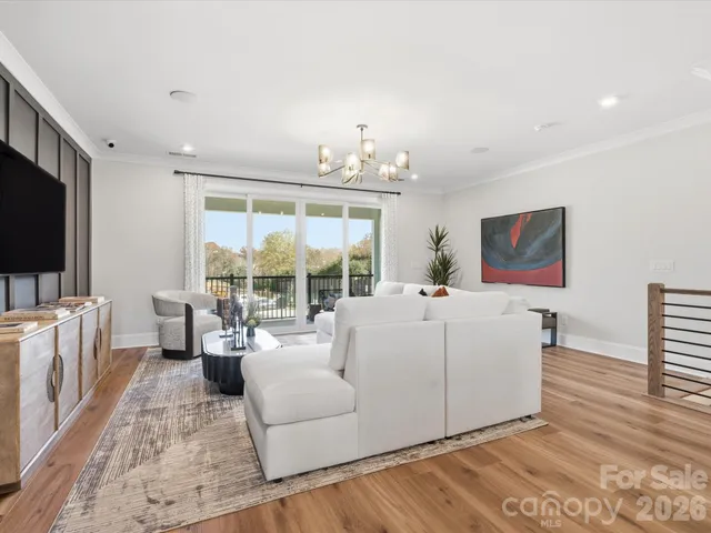 a living room with furniture kitchen view and a chandelier