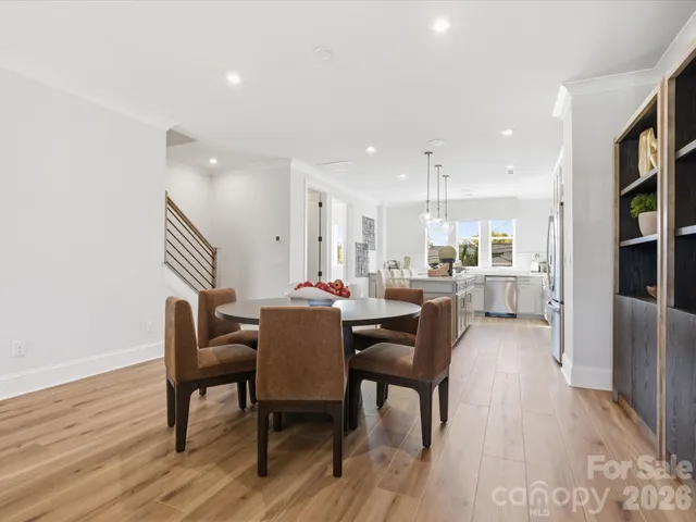 a kitchen with stainless steel appliances granite countertop a stove a sink refrigerator and white cabinets with wooden floor