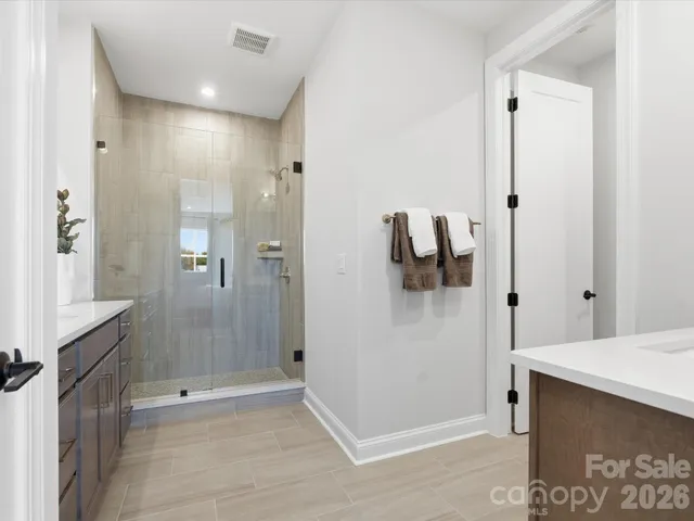 a en suite bathroom with a double vanity sink and a mirror