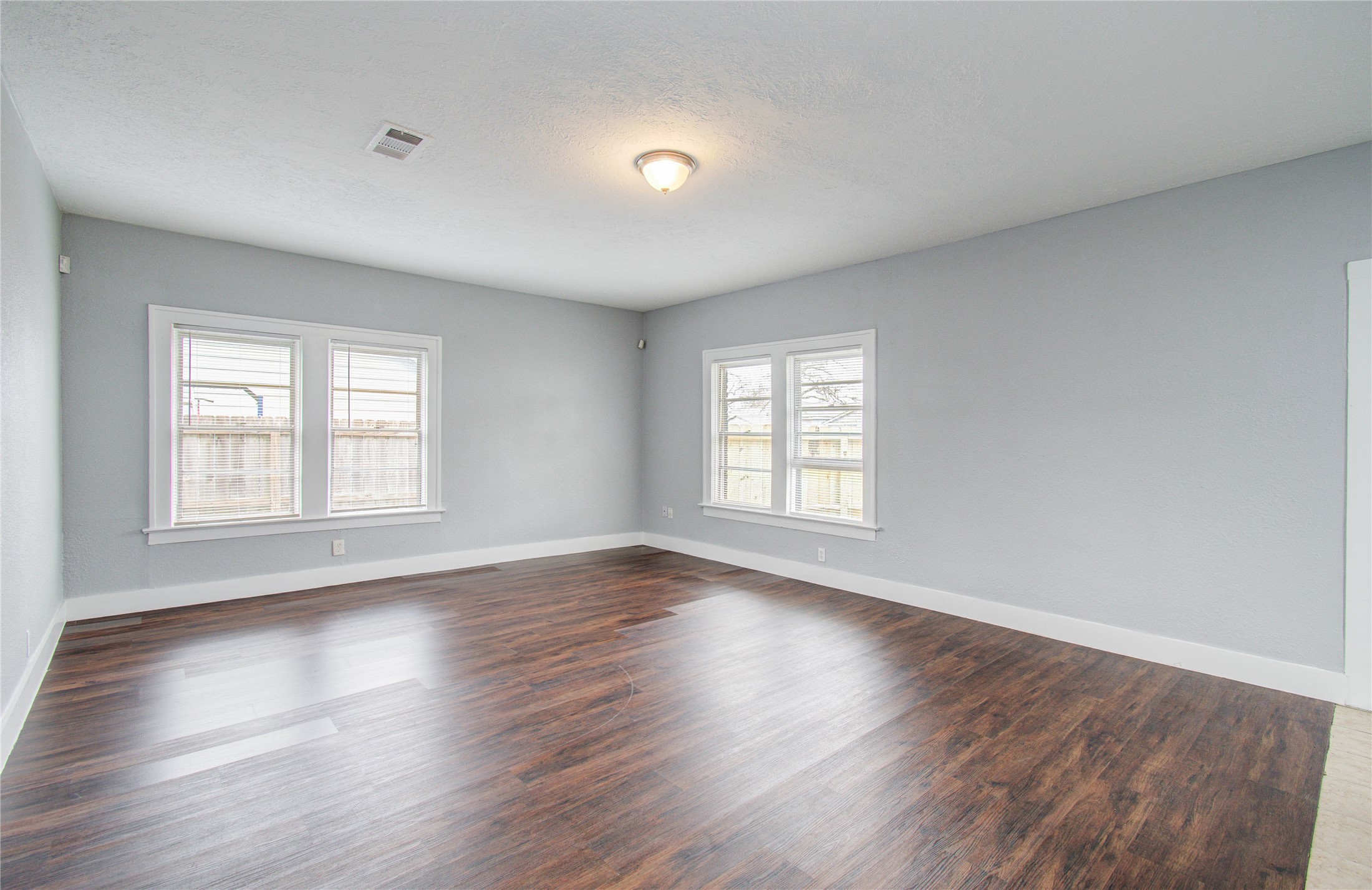 3824 Topping Street Houston, TX 77093 - Photo 11 of 31 an empty room with wooden floor and windows