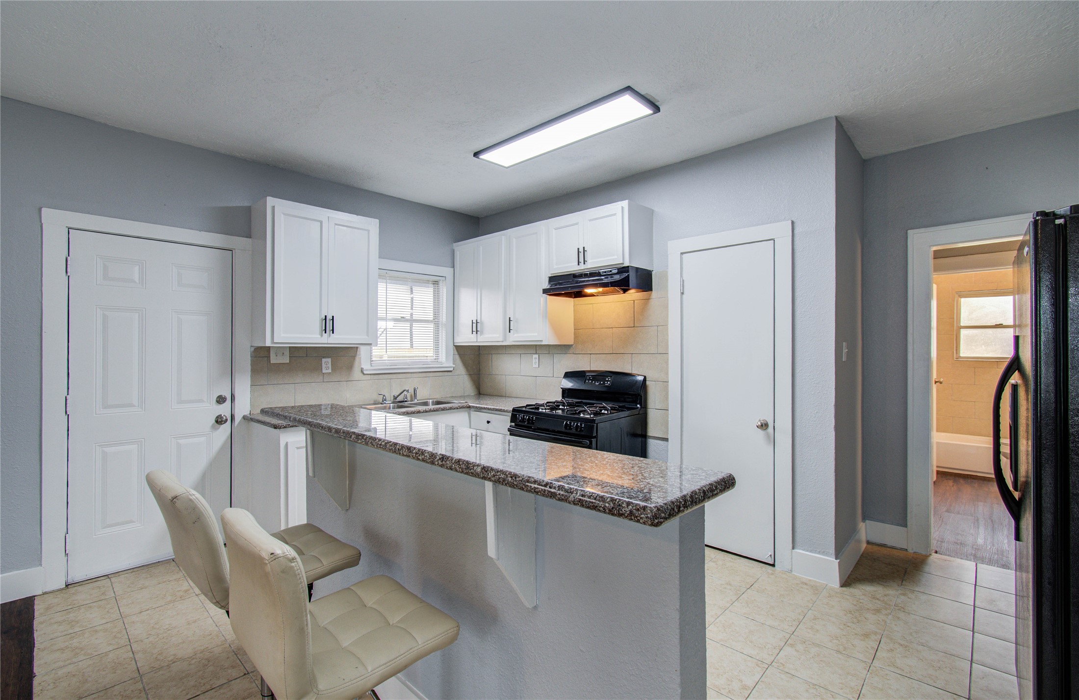3824 Topping Street Houston, TX 77093 - Photo 15 of 31 a kitchen with granite countertop a sink stove and refrigerator