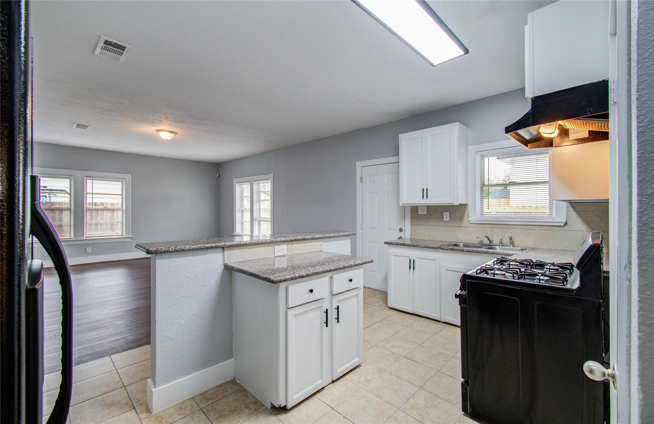 3824 Topping Street Houston, TX 77093 - Photo 17 of 31 a kitchen with a granite countertop sink stove and cabinets