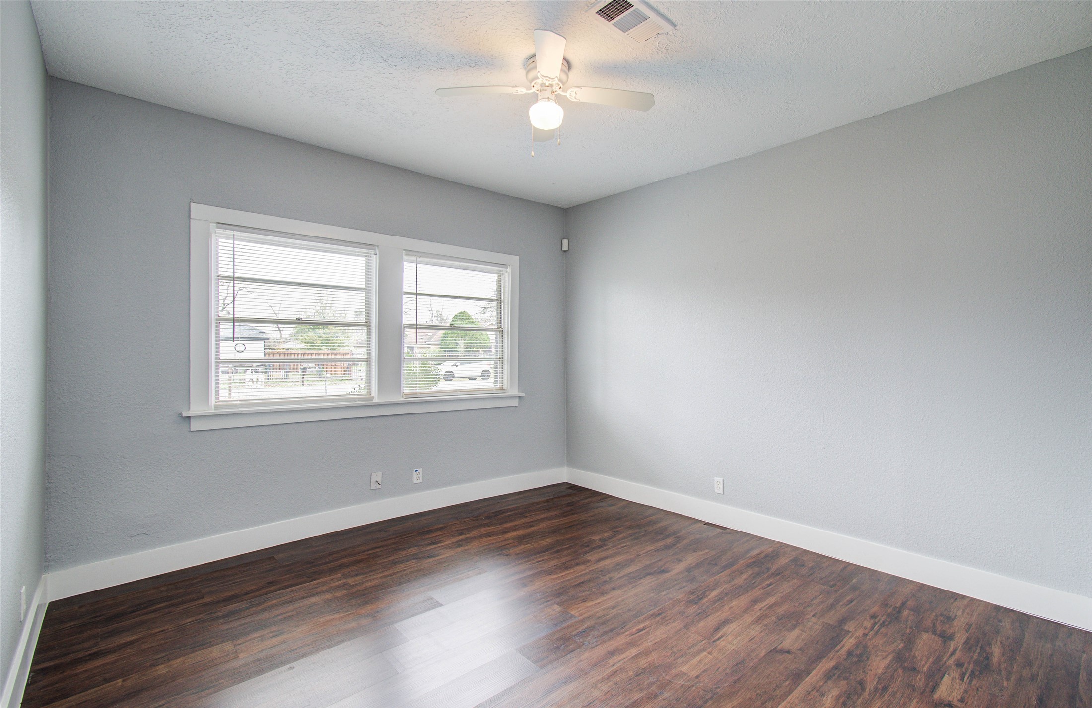 3824 Topping Street Houston, TX 77093 - Photo 26 of 31 an empty room with wooden floor ceiling fan and windows