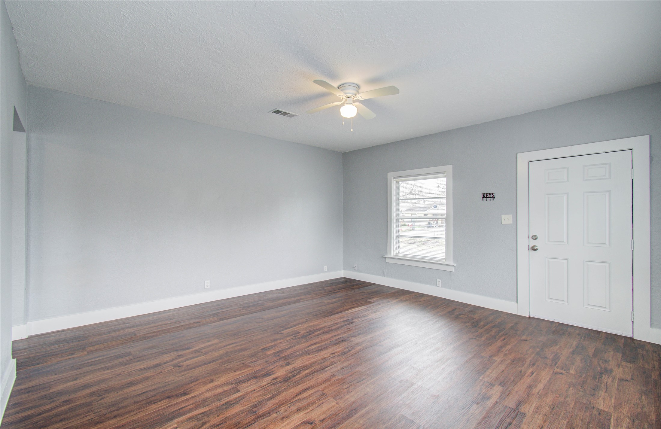 3824 Topping Street Houston, TX 77093 - Photo 8 of 31 a view of an empty room with wooden floor and a window