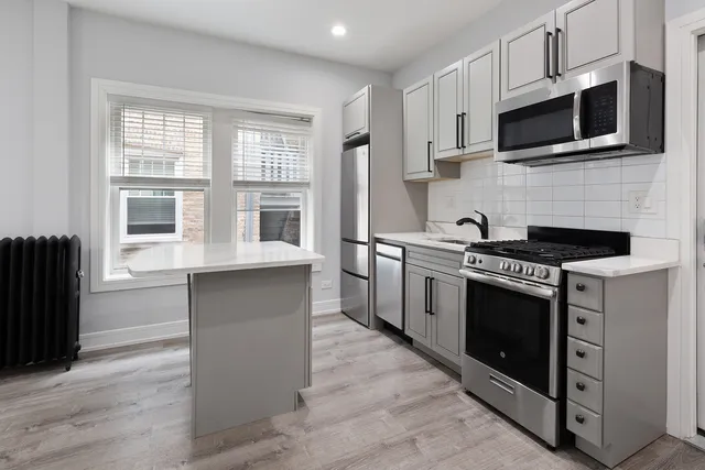 a kitchen with stainless steel appliances a stove microwave and sink