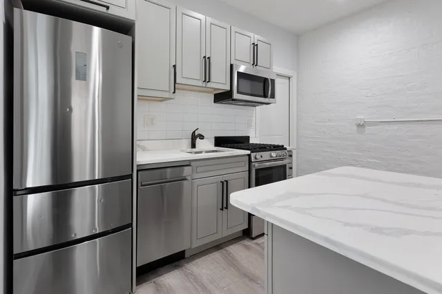 a kitchen with stainless steel appliances a refrigerator stove microwave and sink