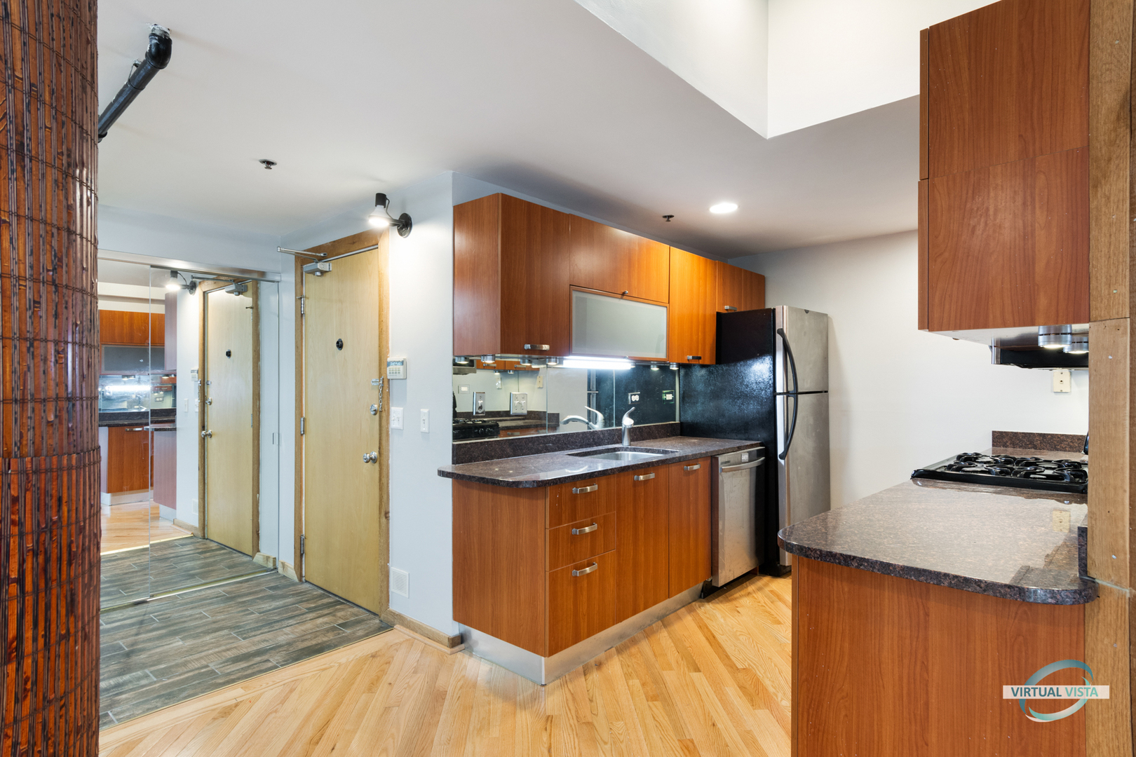 732 South Financial Place, Unit 104 Chicago, IL 60605 - Photo 2 of 30 a kitchen with stainless steel appliances granite countertop a sink and a refrigerator