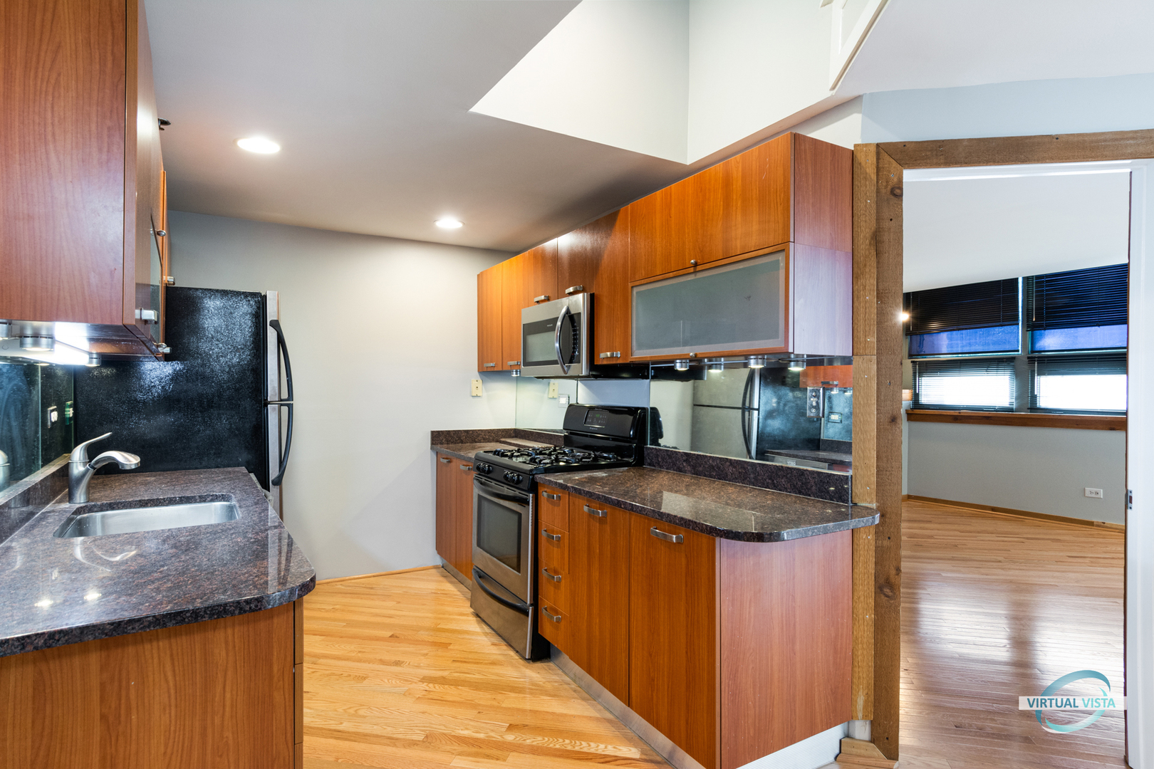 732 South Financial Place, Unit 104 Chicago, IL 60605 - Photo 3 of 30 a kitchen with stainless steel appliances granite countertop a sink a stove and a refrigerator