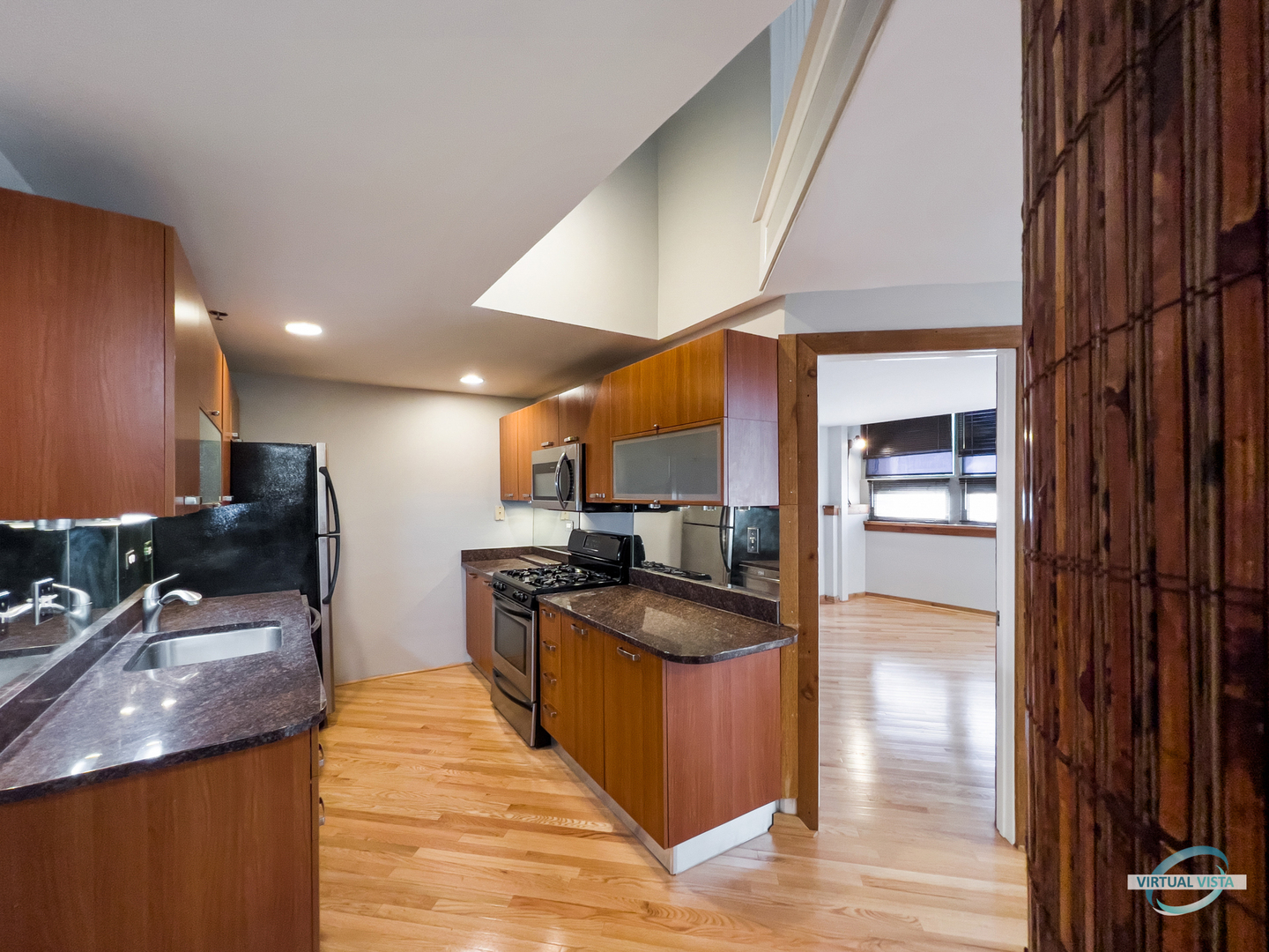732 South Financial Place, Unit 104 Chicago, IL 60605 - Photo 9 of 30 a kitchen with stainless steel appliances granite countertop a sink a stove and a refrigerator