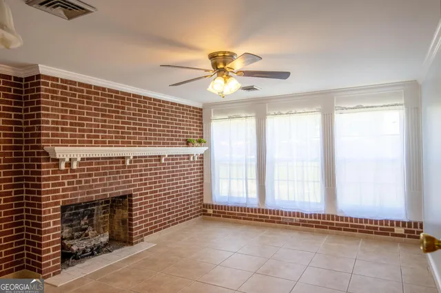a view of an empty room with a window and a fireplace