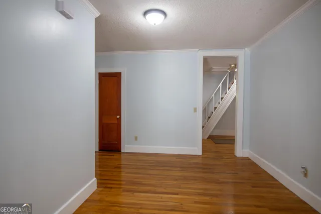 a view of an empty room with wooden floor
