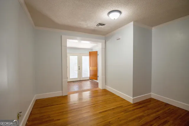a view of an empty room with wooden floor
