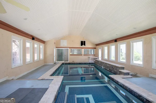 a large white kitchen with granite countertop a stove a sink and a large window