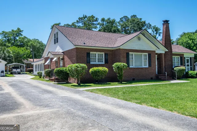 a view of a house with a yard and potted plants