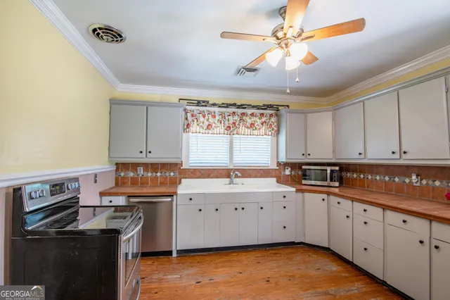 a kitchen with a sink stove and cabinets