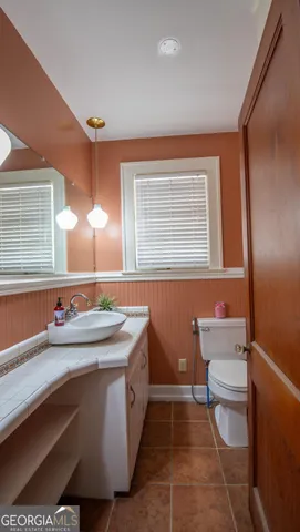 a bathroom with a sink a toilet and mirror