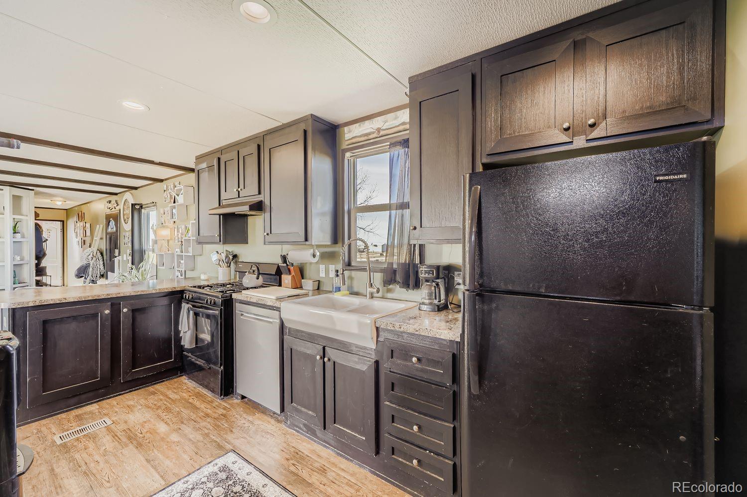 27604 Mucho Grande View Road Calhan, CO 80808 - Photo 6 of 16 a kitchen with a refrigerator sink and cabinets