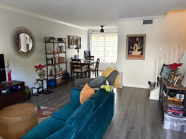a living room with furniture and wooden floor