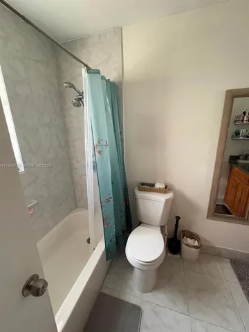 a white toilet sitting next to a bath tub and a shower
