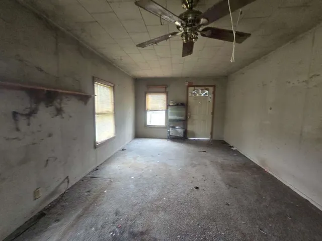 a view of a livingroom with a ceiling fan and window