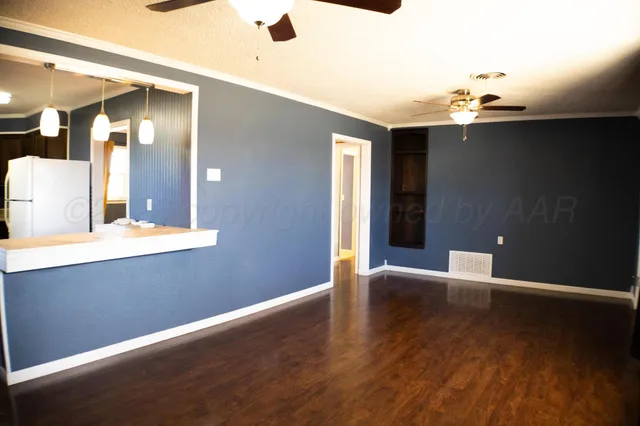 a view of an empty room with wooden floor