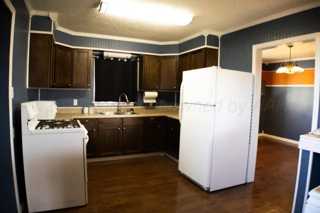 a kitchen with refrigerator and cabinets