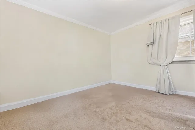 a view of a white house with a large windows and a yard