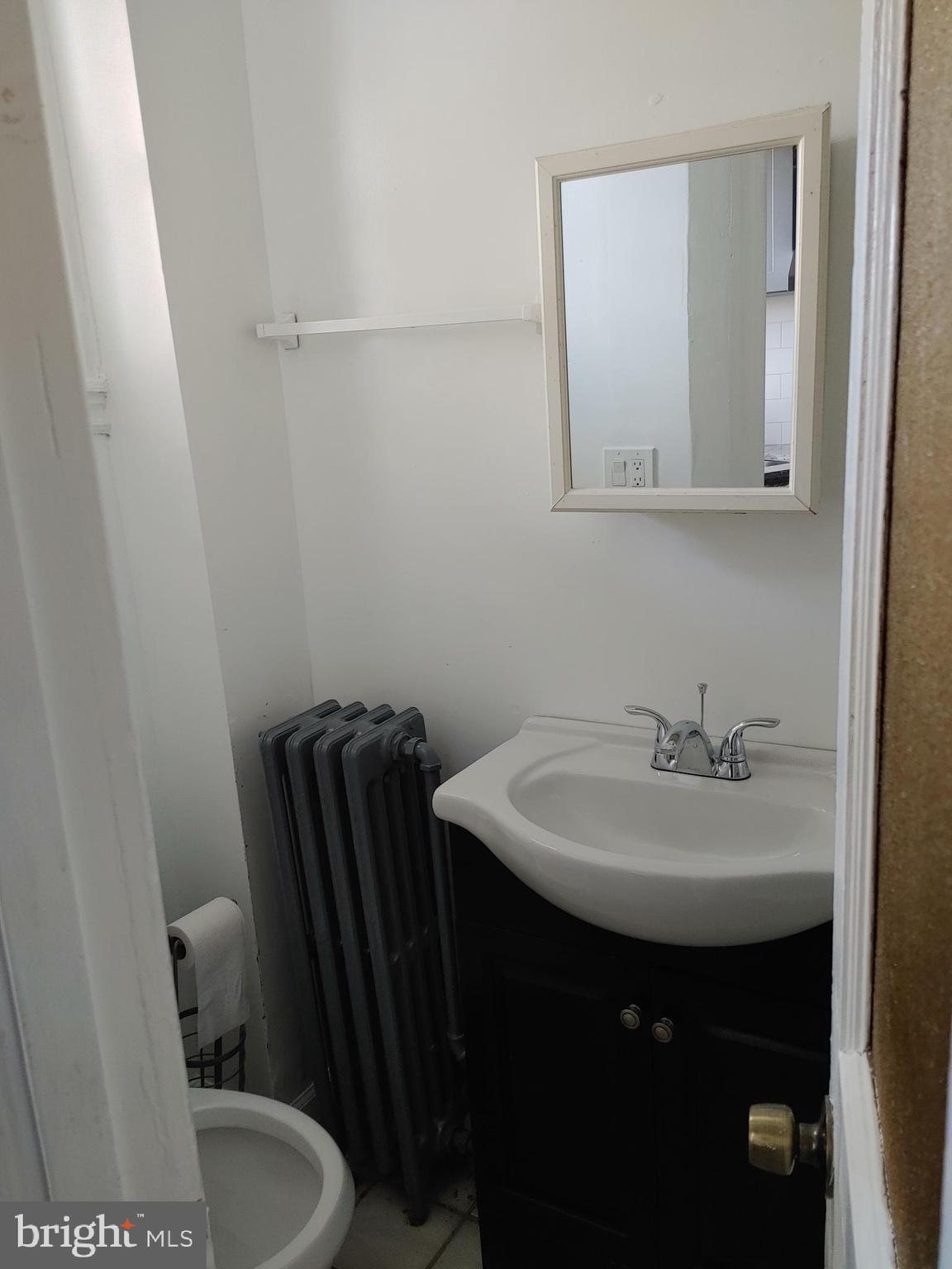 5917 Spruce Street, Unit 1 Philadelphia, PA 19139 - Photo 12 of 15 a bathroom with a sink a toilet and mirror