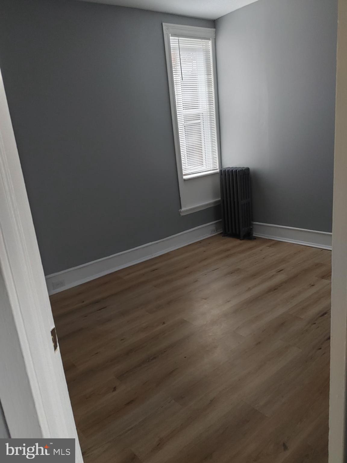 5917 Spruce Street, Unit 1 Philadelphia, PA 19139 - Photo 3 of 15 an empty room with wooden floor and windows
