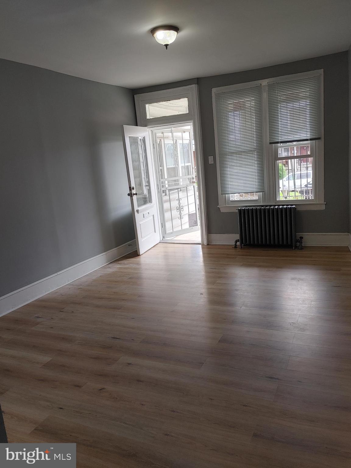5917 Spruce Street, Unit 1 Philadelphia, PA 19139 - Photo 4 of 15 an empty room with wooden floor and windows
