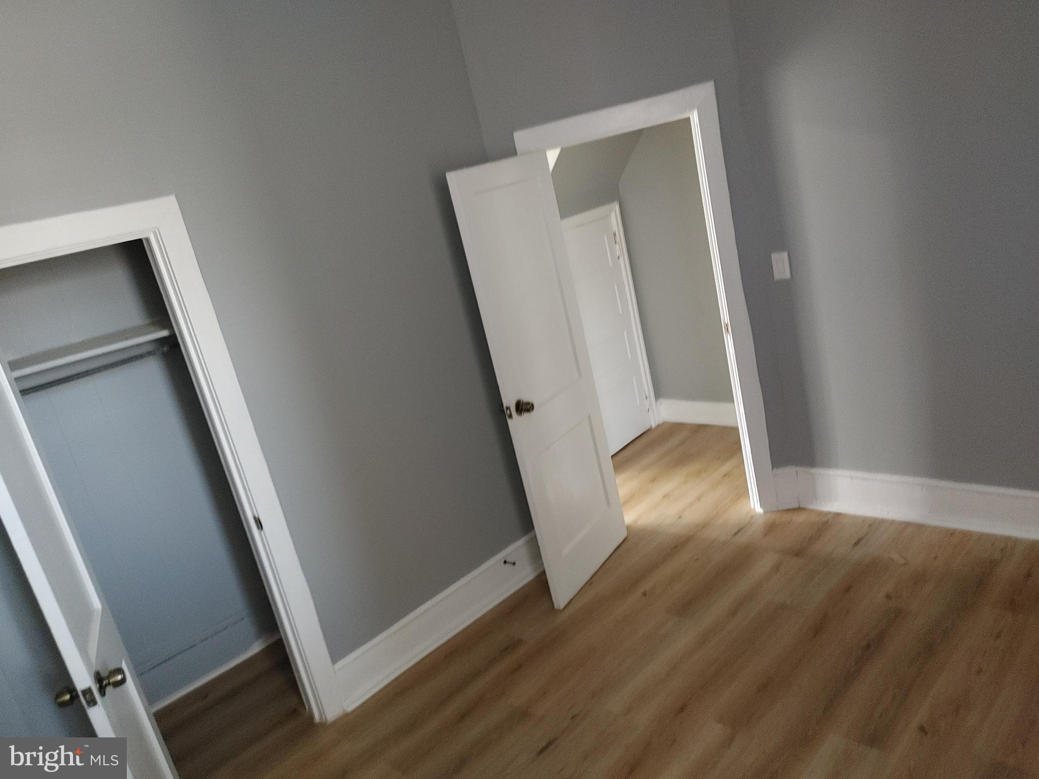 5917 Spruce Street, Unit 1 Philadelphia, PA 19139 - Photo 6 of 15 an empty room with wooden floor and staircase