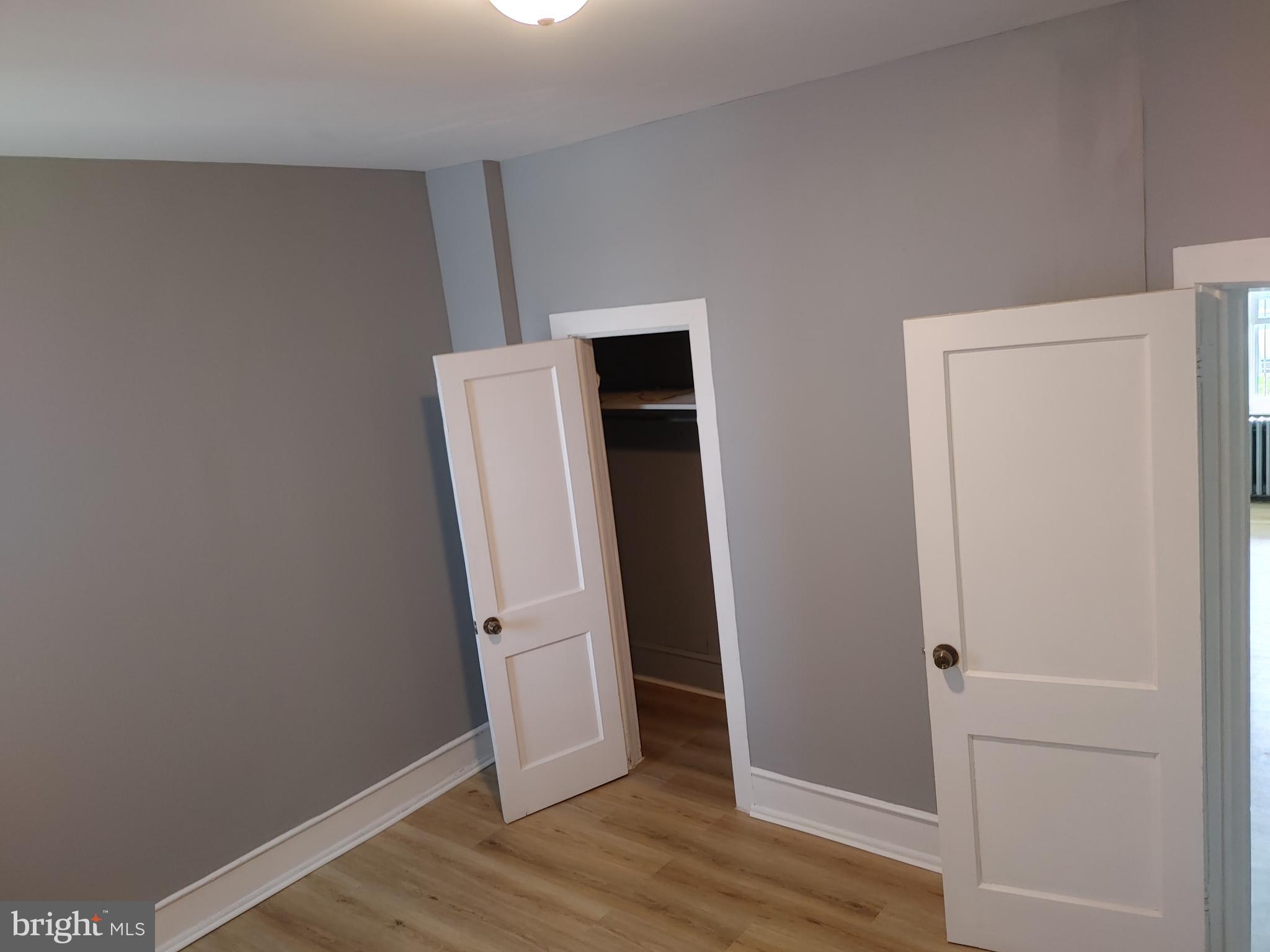 5917 Spruce Street, Unit 1 Philadelphia, PA 19139 - Photo 7 of 15 an empty room with wooden floor and closet