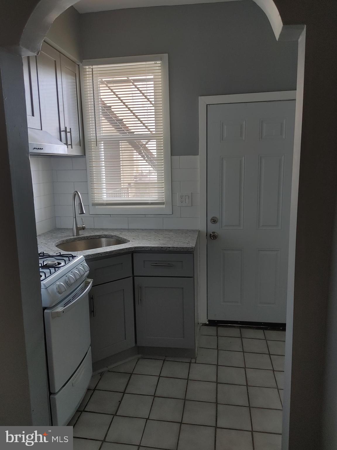 5917 Spruce Street, Unit 1 Philadelphia, PA 19139 - Photo 10 of 15 a kitchen with stainless steel appliances granite countertop a sink stove and refrigerator