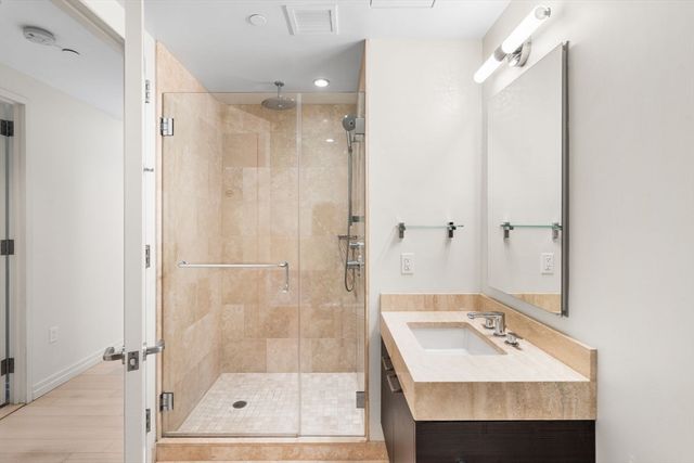 a bathroom with a sink shower and a mirror
