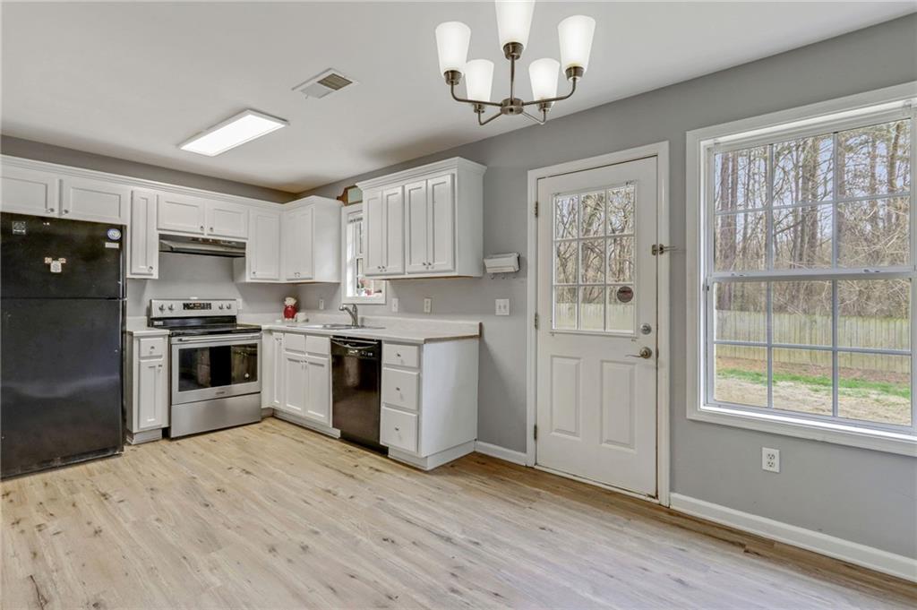 54 Taylorsville Road Aragon, GA 30104 - Photo 18 of 29 a kitchen with granite countertop wooden floors stainless steel appliances and window