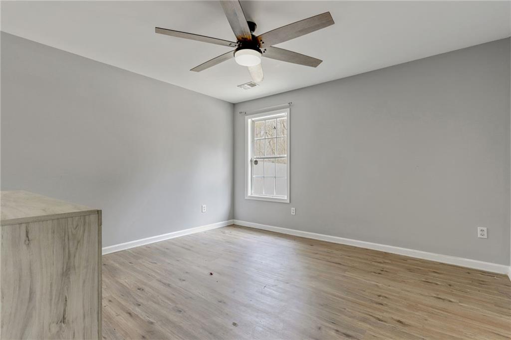54 Taylorsville Road Aragon, GA 30104 - Photo 24 of 29 an empty room with wooden floor chandelier fan and windows