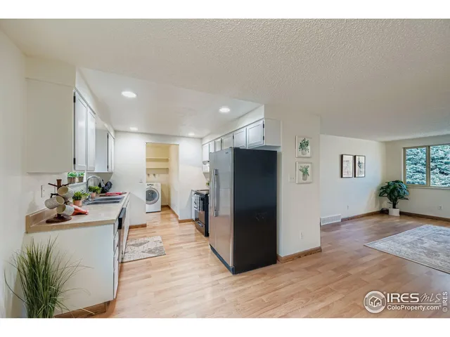 a living room with furniture a refrigerator and a sink