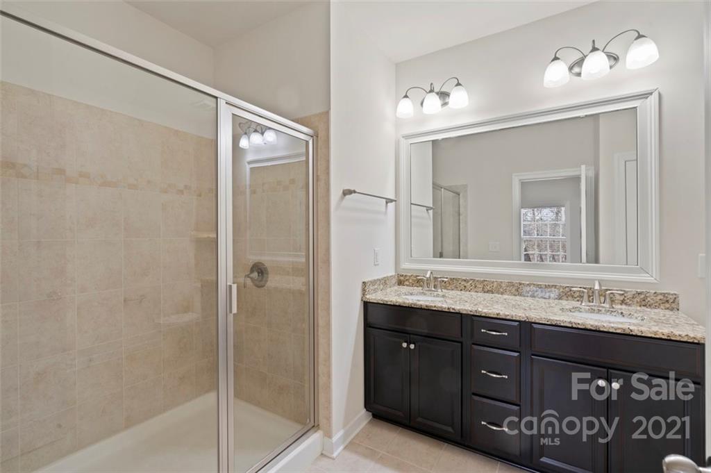 4331 Oxford Mill Road Waxhaw, NC 28173 - Photo 21 of 48 a bathroom with a granite countertop sink a mirror and a shower