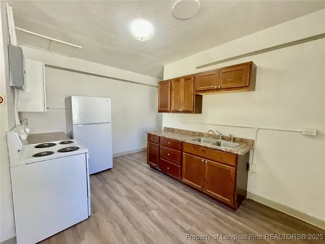 a kitchen with stainless steel appliances granite countertop a stove a sink and a refrigerator
