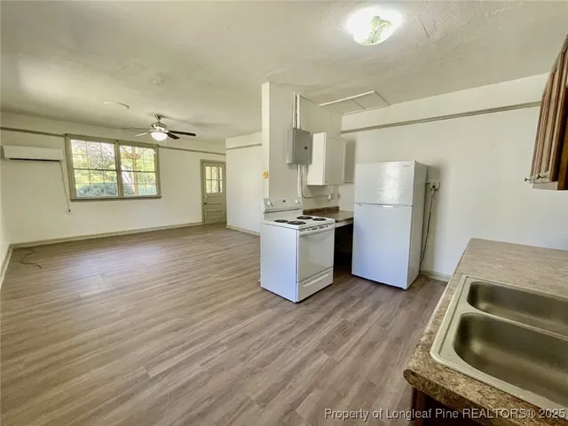 a kitchen with a refrigerator wooden floor and a sink