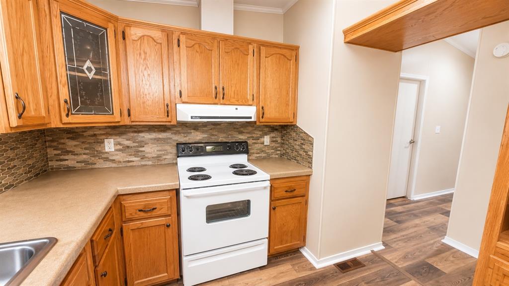 9455 Tranquil Acres Road Fort Worth, TX 76179 - Photo 14 of 20 Kitchen featuring light wood cabinetry, a decorative glass cabinet door, and a tiled backsplash