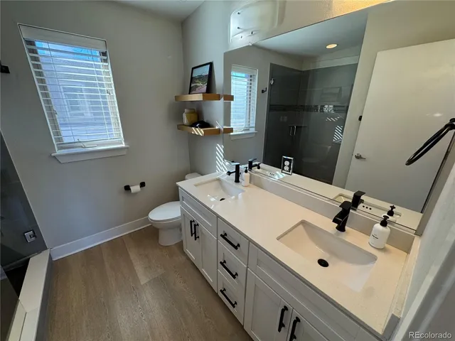 a bathroom with a double vanity sink toilet and mirror