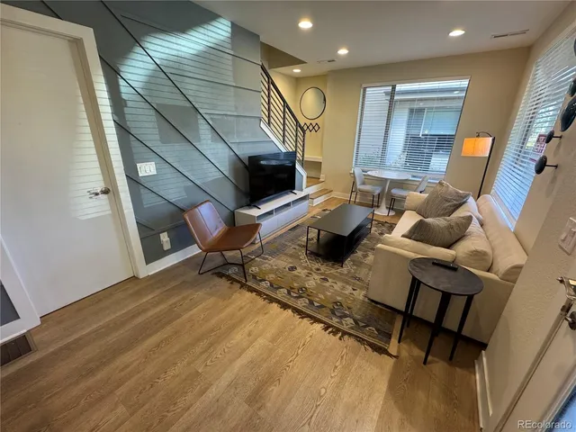 a living room with furniture and a wooden floor