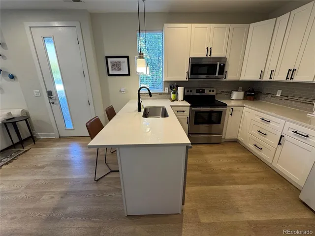 a kitchen with a sink appliances and wooden cabinets