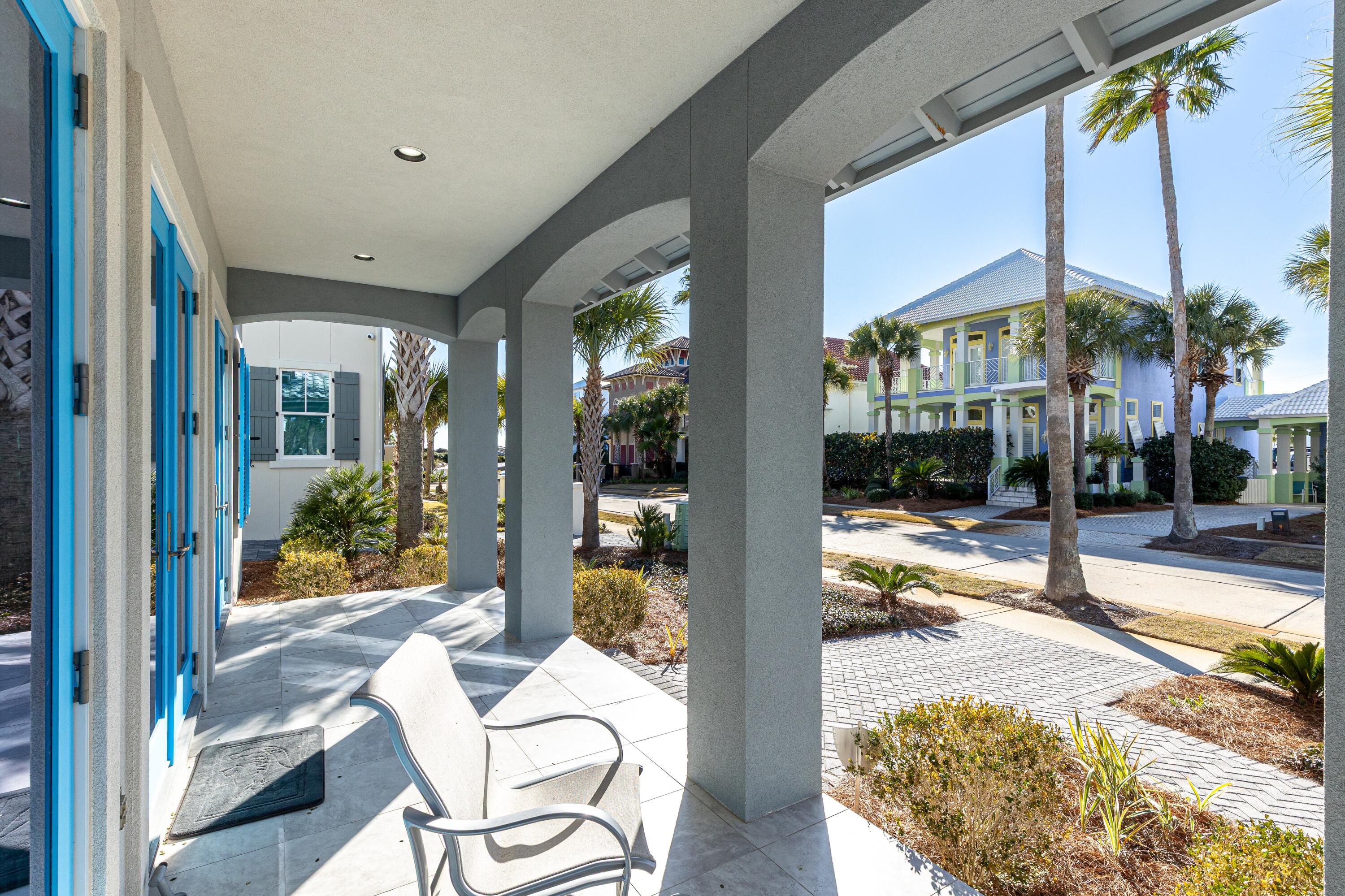 265 Rue Martine Miramar Beach, FL 32550 - Photo 7 of 82 a view of a patio with couches chairs and floor to ceiling window next to a yard
