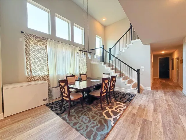 a kitchen with stainless steel appliances kitchen island granite countertop a refrigerator a stove a sink dishwasher and a dining table with wooden floor