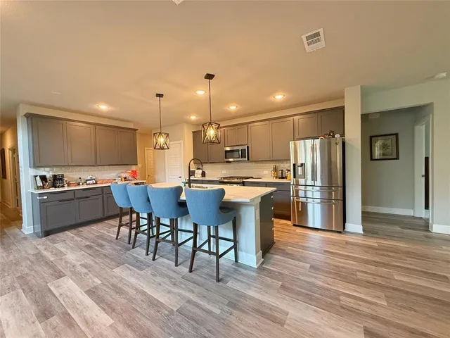 a kitchen with stainless steel appliances granite countertop wooden cabinets a stove top oven a sink and dishwasher