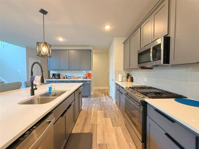 a kitchen with kitchen island granite countertop a sink stainless steel appliances and cabinets